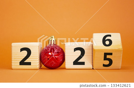 2026 New Year symbol. Businessman turns wooden cube and changes Year 2025 to 2026. Beautiful orange background with christmas ball. Copy space. Business and 2026 happy new year concept 2026 New Year symbol. Businessman turns wooden cube and changes Year 2025 to 2026. Beautiful orange background with christmas ball. Copy space. Business and 2026 happy new year concept 133412621