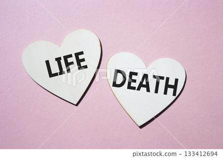 Life or Death symbol. Concept word Life or Death on wooden hearts. Beautiful pink background. Business and Life or Death concept. Copy space 133412694