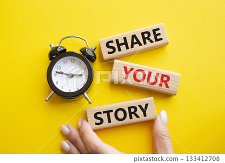 Share your story symbol. Wooden blocks with words Share your story. Businessman hand. Beautiful yellow background with alarm clock. Business and Share your story concept. Copy space. 133412708