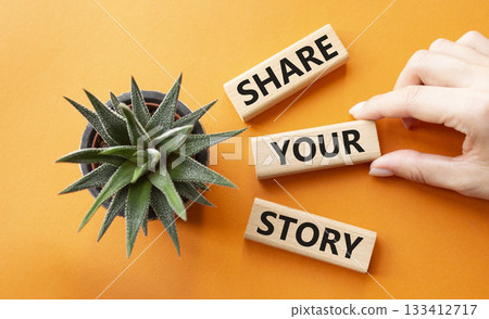 Share your story symbol. Wooden blocks with words Share your story. Beautiful orange background with succulent plant. Businessman hand. Business and Share your story concept. Copy space. Share your story symbol. Wooden blocks with words Share your story. Beautiful orange background with succulent plant. Businessman hand. Business and Share your story concept. Copy space. 133412717