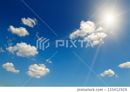 Brilliant Sun with Starburst Effect in Deep Blue Sky with White Clouds Brilliant Sun with Starburst Effect in Deep Blue Sky with White Clouds 133412929