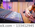 close up male musician hands playing acoustic guitar in home studio, recording concept. 133412945