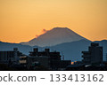 The silhouette of Mt. Fuji and the cityscape in the orange sunset sky seen from the bank of the Tama River 133413162