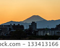 The silhouette of Mt. Fuji and the cityscape in the orange sunset sky seen from the bank of the Tama River 133413166