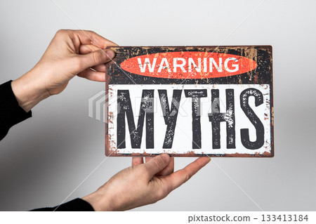 Vintage Warning Sign with the Word Myths Held by Hands on Neutral Background Vintage Warning Sign with the Word Myths Held by Hands on Neutral Background 133413184
