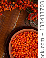 ripe sea buckthorn berries with  branch on wooden table. close up. flat lay 133413703
