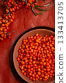 ripe sea buckthorn berries with  branch on wooden table. flat lay 133413705