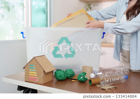 Eco-Friendly Living. Woman organizing recyclable materials in bin, promoting sustainability. 133414804