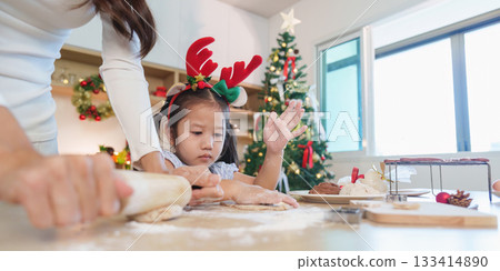 Christmas baking with child. Family making cookies together in festive kitchen. Christmas baking with child. Family making cookies together in festive kitchen. 133414890
