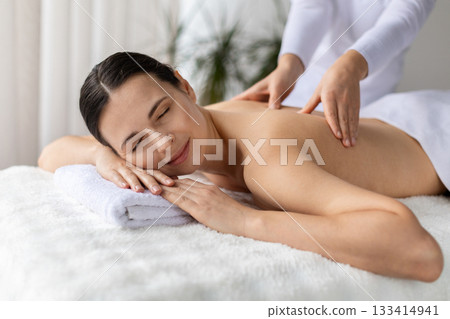 Beautiful woman having full body massage treatment at modern spa Beautiful woman having full body massage treatment at modern spa 133414941