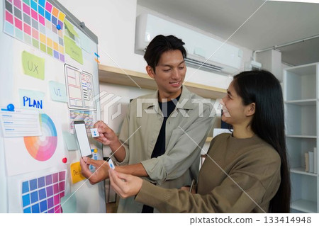 Creative Collaboration. Young professionals discussing UI design ideas. 133414948
