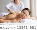 Young woman receiving gentle upper back massage at spa 133414961