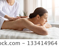 Young woman relaxing during gentle back massage at modern spa center 133414964