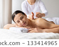Young female enjoying relaxing back massage at spa, eyes closed 133414965