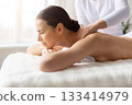 Young female receiving shoulder and upper back massage at spa 133414979