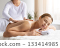 Young woman receiving calming back massage at modern spa center 133414985