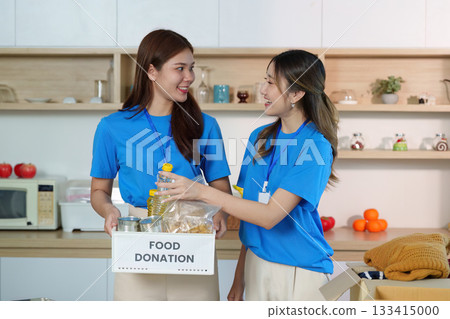 Community Support. Two volunteers sharing food donations in a community center. Community Support. Two volunteers sharing food donations in a community center. 133415000