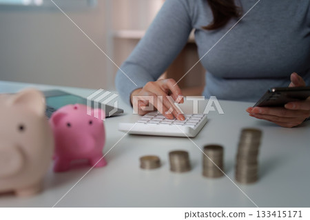 Budgeting: Woman Using Calculator and Smartphone for Financial Planning 133415171