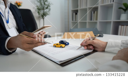 Vehicle Insurance Consultation. Agent explaining policy with model cars. Vehicle Insurance Consultation. Agent explaining policy with model cars. 133415228