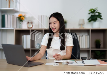 Financial Management. Young woman managing finances on a laptop at home. Financial Management. Young woman managing finances on a laptop at home. 133415272