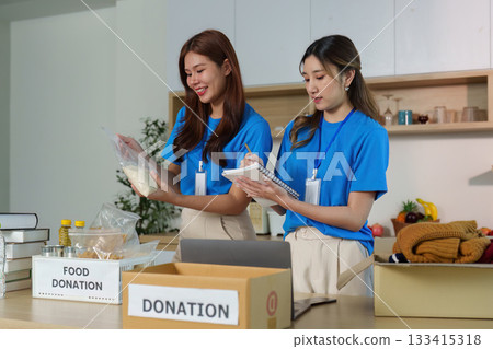 Food Donation. Volunteers collaborating to organize food items for charity. 133415318