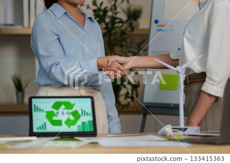 ESG Partnership. Business professionals shaking hands over sustainability goals. ESG Partnership. Business professionals shaking hands over sustainability goals. 133415363