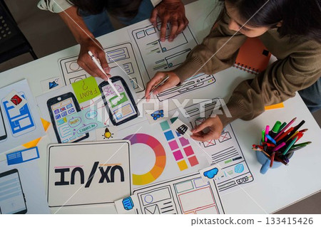Creative Process. Overhead view of designers collaborating on UI UX wireframes and sketches. Creative Process. Overhead view of designers collaborating on UI UX wireframes and sketches. 133415426
