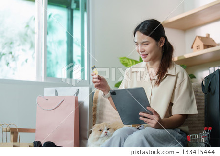 Digital Shopping. Woman using tablet and credit card for online purchase with cat. 133415444