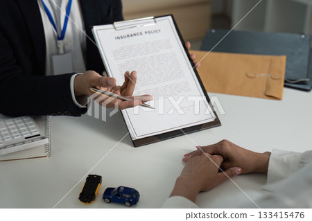 Insurance Consultation. Client discussing policy details with agent in office. Insurance Consultation. Client discussing policy details with agent in office. 133415476