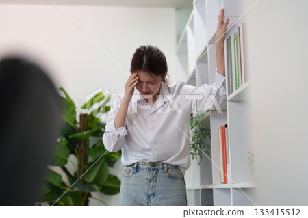 Emotional Distress. Young woman struggling with stress in a contemporary office. 133415512
