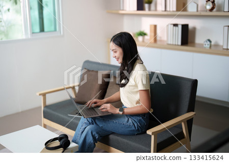 Remote Work. Young woman engaged in online tasks at home. 133415624