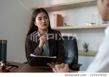 Legal Consultation. Professional lawyer discussing case details with a client in an office. 133415630