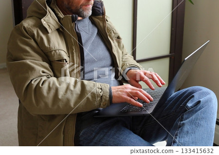 Man working on laptop indoors Man working on laptop indoors 133415632