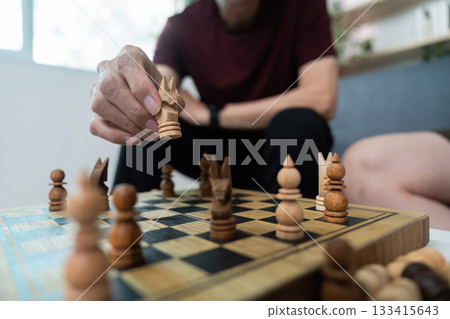 Chess Game Strategy. Two friends engaged in a thoughtful chess match indoors. 133415643