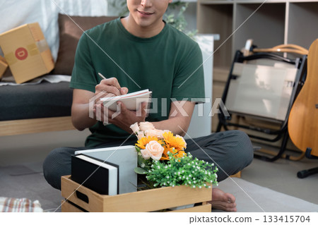 Man Taking Notes While Organizing Home Decor 133415704