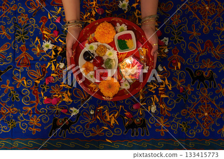 Colorful Puja Thali with Ritual Offerings and Flowers 133415773