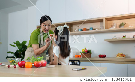 Healthy Cooking. Mother and daughter enjoying fun cooking time in modern kitchen. Healthy Cooking. Mother and daughter enjoying fun cooking time in modern kitchen. 133415791