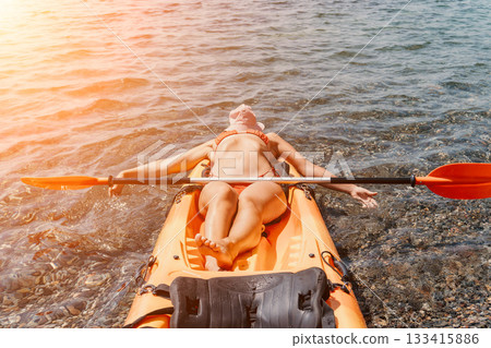 Kayaking Woman Water Relaxing Summer: A woman in a kayak enjoys a relaxing day on the water with the sun shining down. Kayaking Woman Water Relaxing Summer: A woman in a kayak enjoys a relaxing day on the water with the sun shining down. 133415886