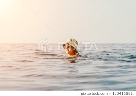 Woman Swimming Sea Hat Summer - A woman in a hat is swimming in the sea on a summer day. 133415891