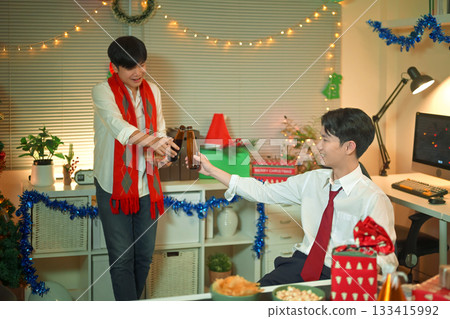 Business people are celebrating holiday in modern office drinking beer and having fun in co working. Merry Christmas and Happy New Year 133415992