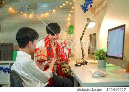 Christmas, gift and excited business people in office for holiday, tradition and celebration. Professional, friends giving present to happy man for festive season, xmas party and surprise Christmas, gift and excited business people in office for holiday, tradition and celebration. Professional, friends giving present to happy man for festive season, xmas party and surprise 133416017