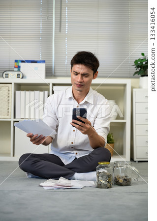 Stressed young man holding so many expenses bills in his hand no money to pay debt Stressed young man holding so many expenses bills in his hand no money to pay debt 133416054