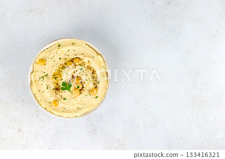 Creamy lupin hummus with olive oil, herbs on white background. Top view. Copy space. Vegan protein-rich dip. 133416321