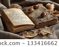 Old open book with handwritten pages and dried flowers on cloth 133416662
