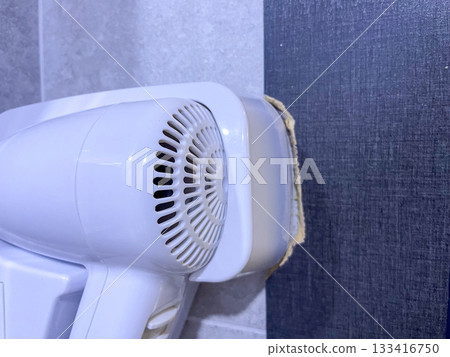 Wall-mounted white hair dryer in bathroom Wall-mounted white hair dryer in bathroom 133416750
