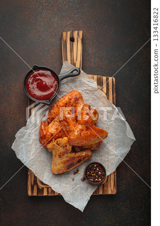 Roasted grilled chicken wings dipping sauce ketchup wooden cutting board barbecue bbq Roasted grilled chicken wings dipping sauce ketchup wooden cutting board barbecue bbq 133416822