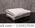 A clean stack of white folded towels in the bathroom 133417036