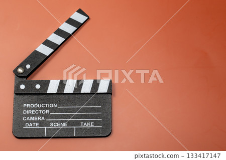 Clapperboard on an orange background, representing filmmaking and the start of a movie. Clapperboard on an orange background, representing filmmaking and the start of a movie. 133417147