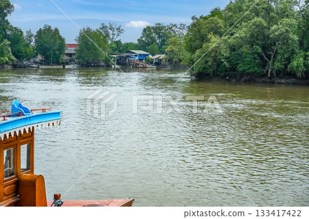 The prow of the Thai style vintage wooden boat floating on the water of a river in Hua Hin, Thailand. The prow of the Thai style vintage wooden boat floating on the water of a river in Hua Hin, Thailand. 133417422