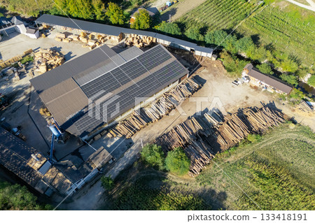 Aerial view of a sawmill factory uses renewable solar energy, with stacks of processed lumber and timber. 133418191